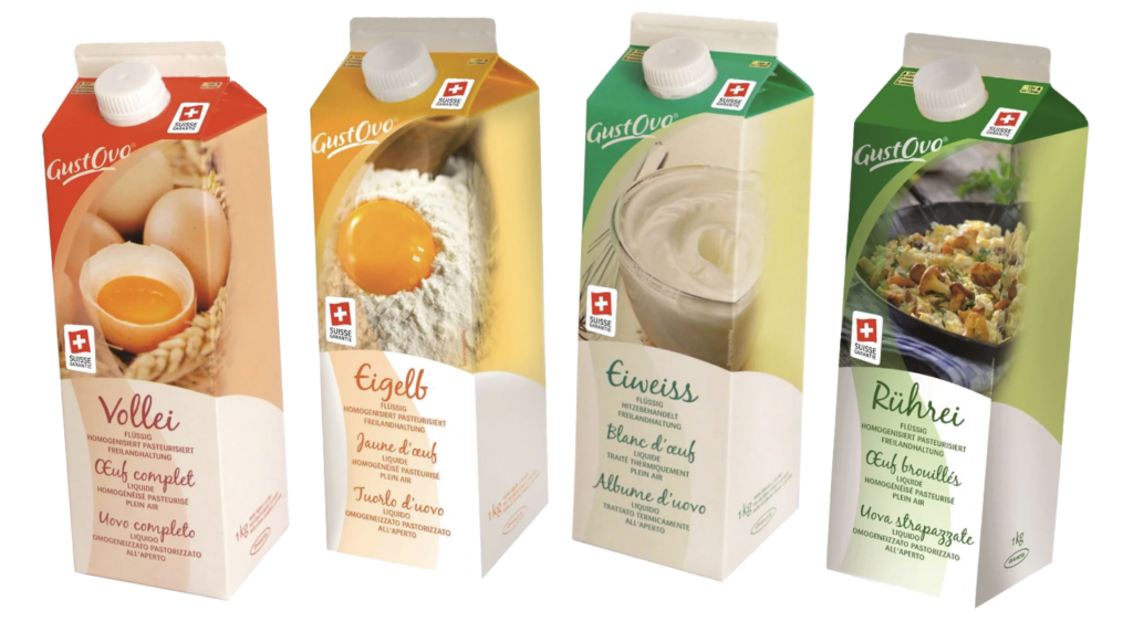 Unsere Produkte 14 Es werden vier Kartons mit Eierprodukten der Marke Gustovo ausgestellt. Von links nach rechts: Vollei, Eigelb, Eiweiß und Rührei. Jeder Karton zeigt ein Bild des jeweiligen Eierprodukts und ein Schweizer Flaggensymbol.